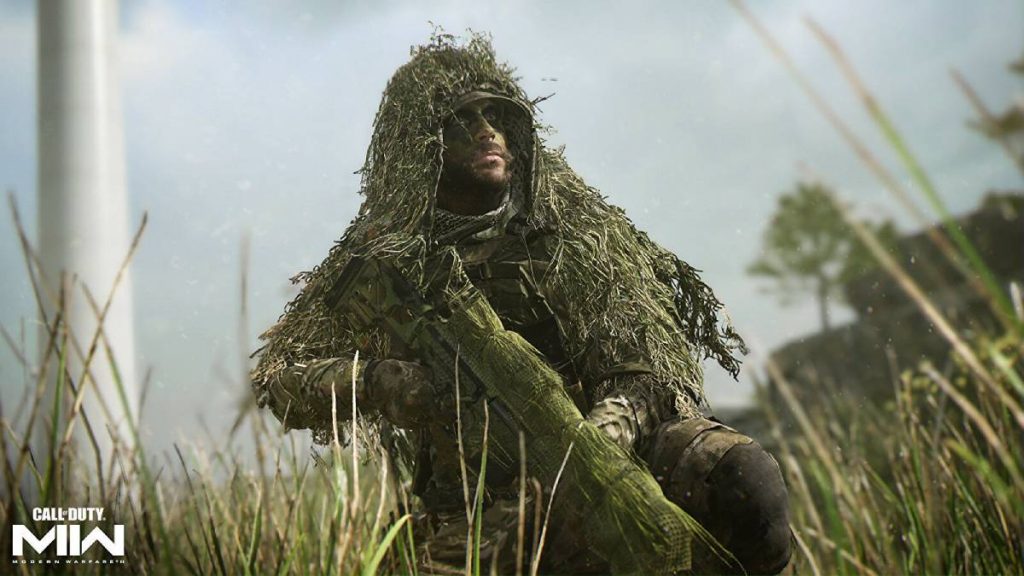 a soldier in a ghillie suit from MW2 crouched in tall grass with a sniper rifle