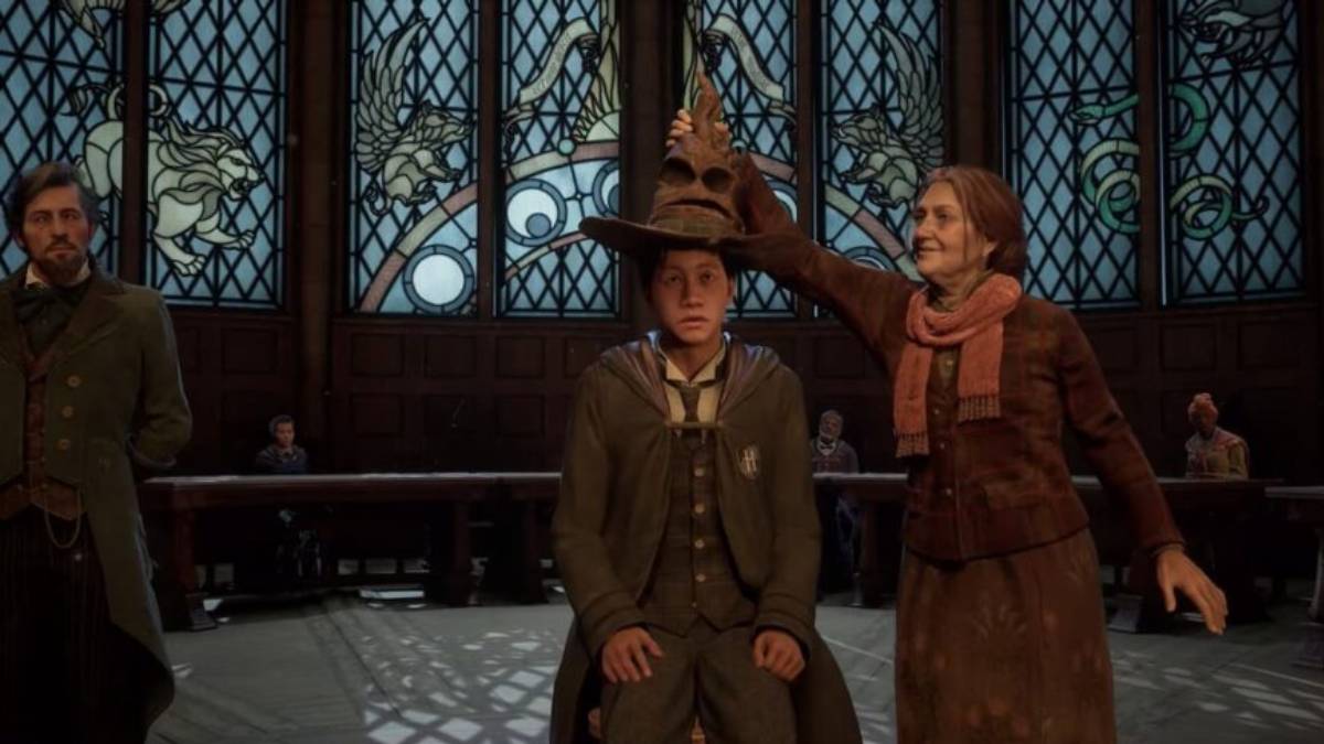 the player character from Hogwarts Legacy sitting on a chair in the Great Hall while a female teacher puts the Sorting Hat on his head